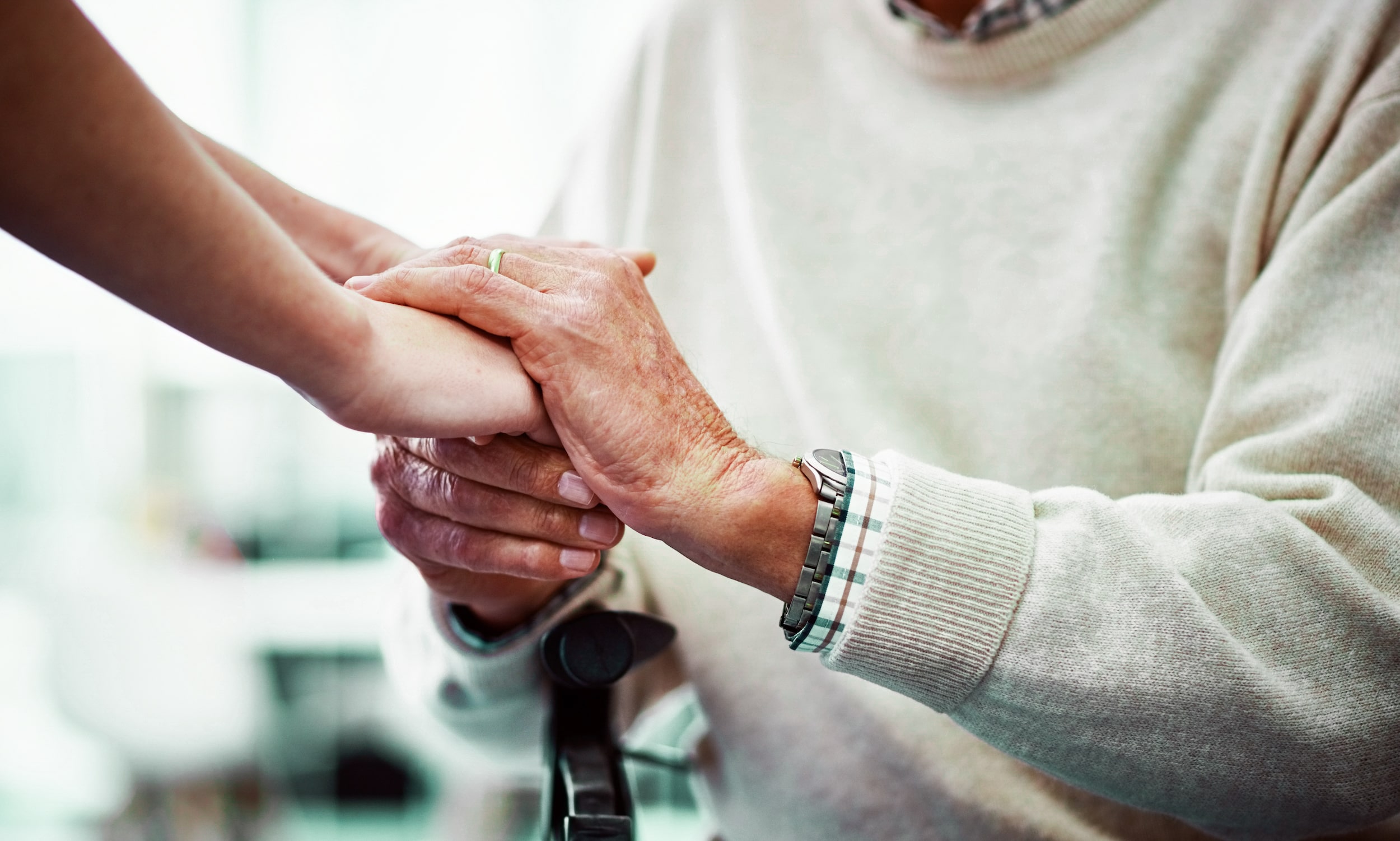 Background Image - A nurse holding a womans hand